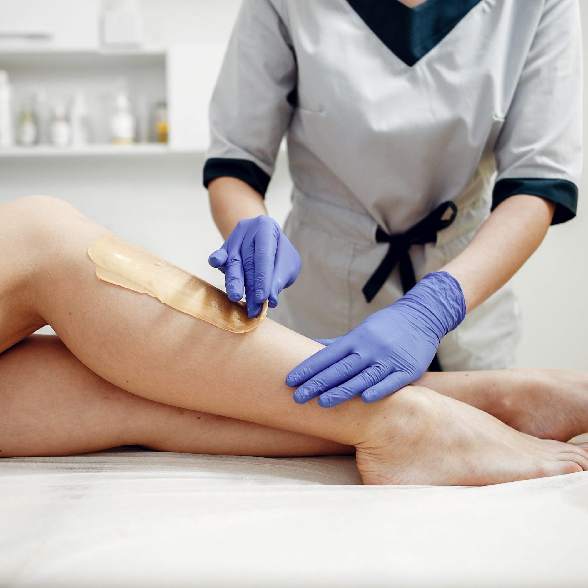 Beautiful girl doing hair removal. Woman in beauty salon